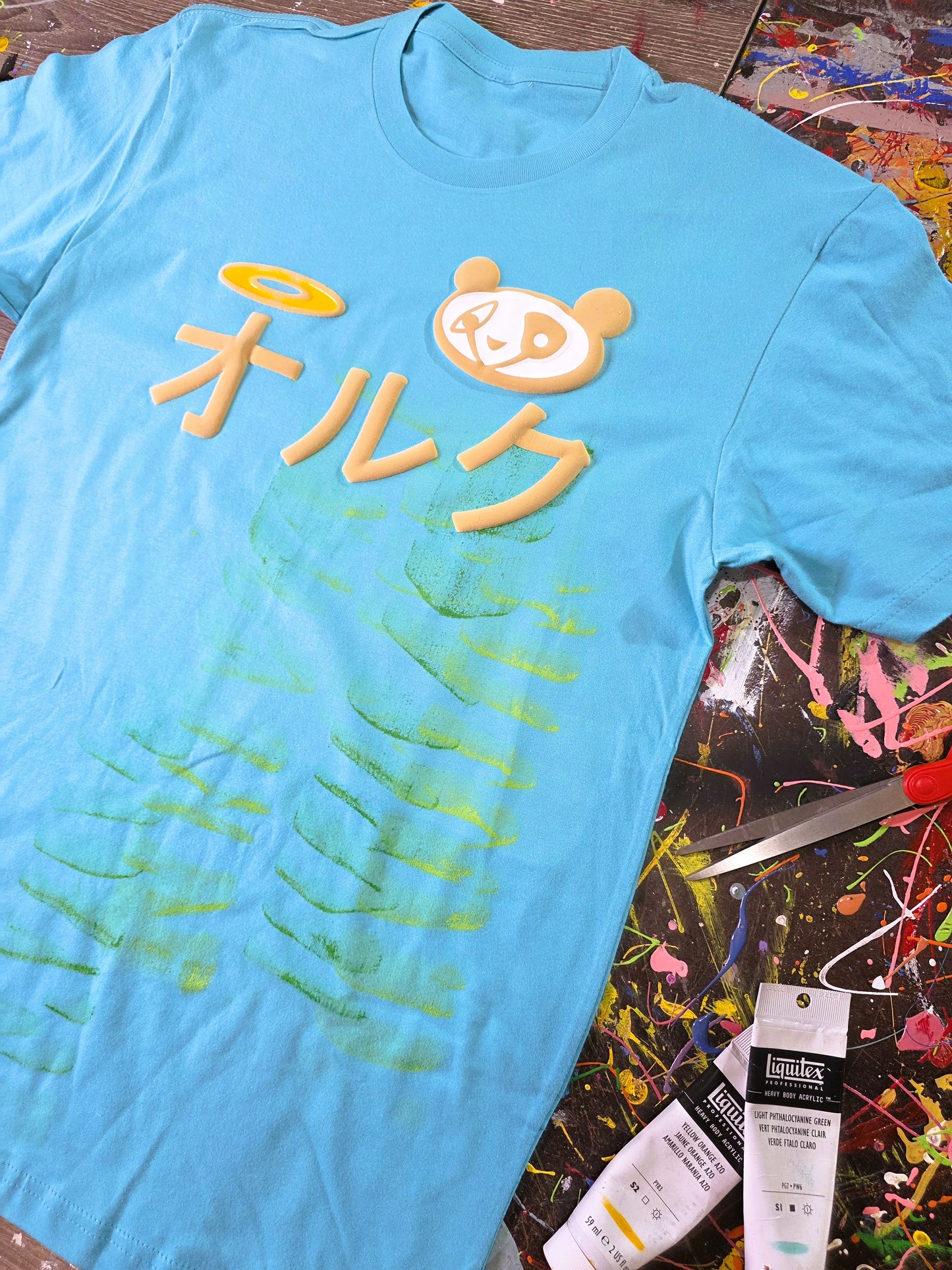 Blue t-shirt with yellow graphics and text on a colorful, abstract background