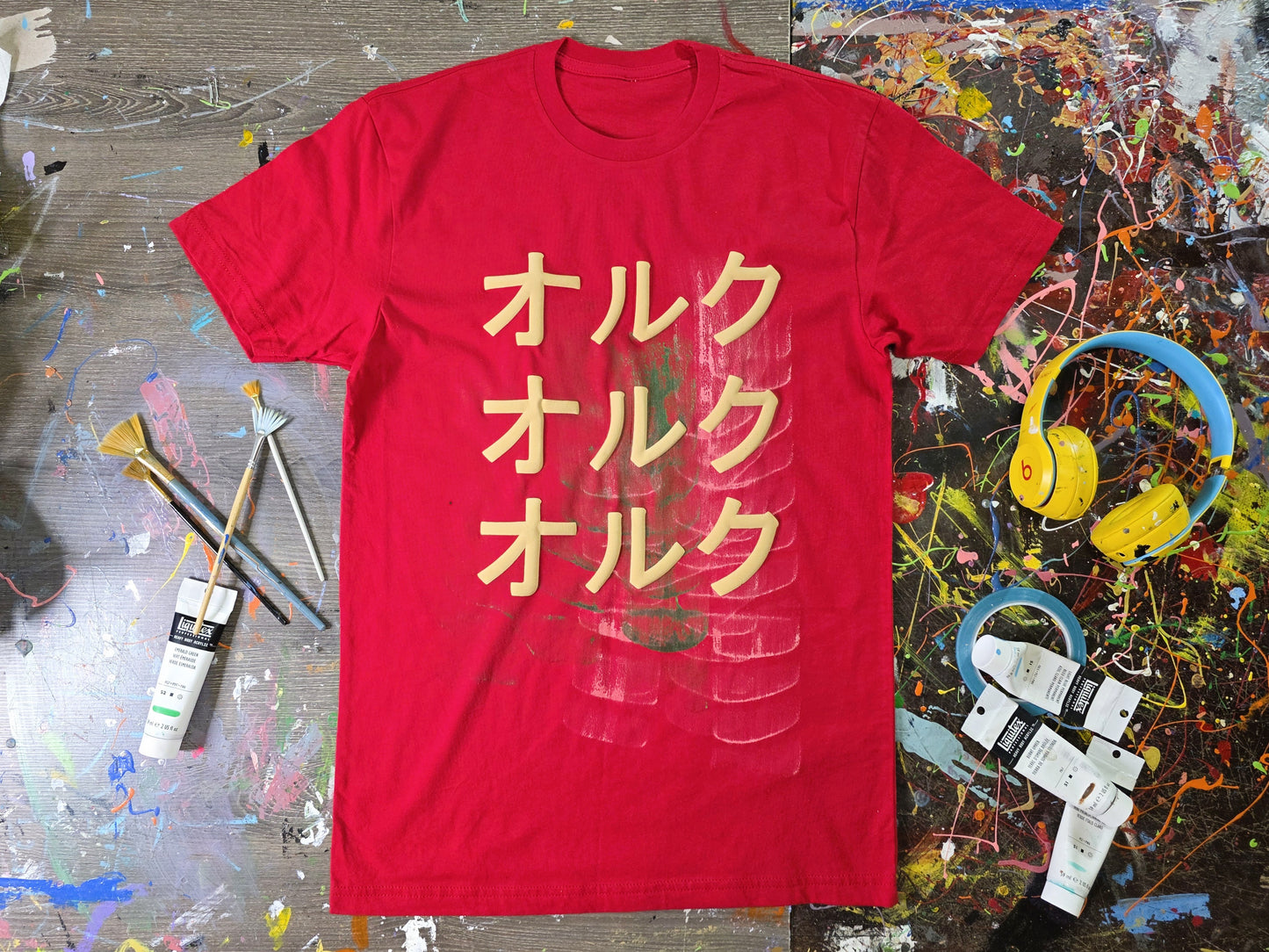 Red t-shirt with yellow text on a colorful, textured surface