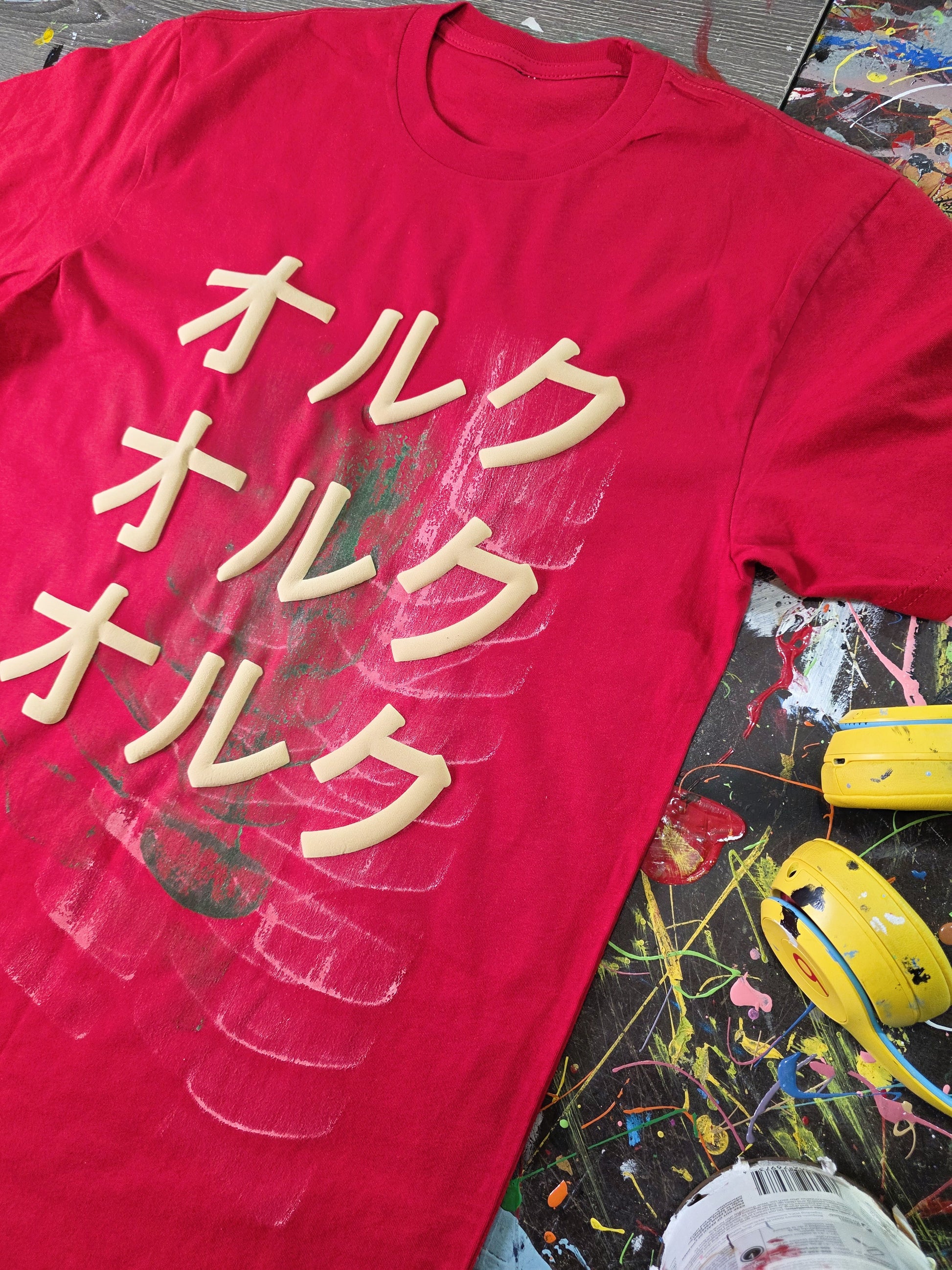 Red t-shirt with white text on a colorful, abstract background